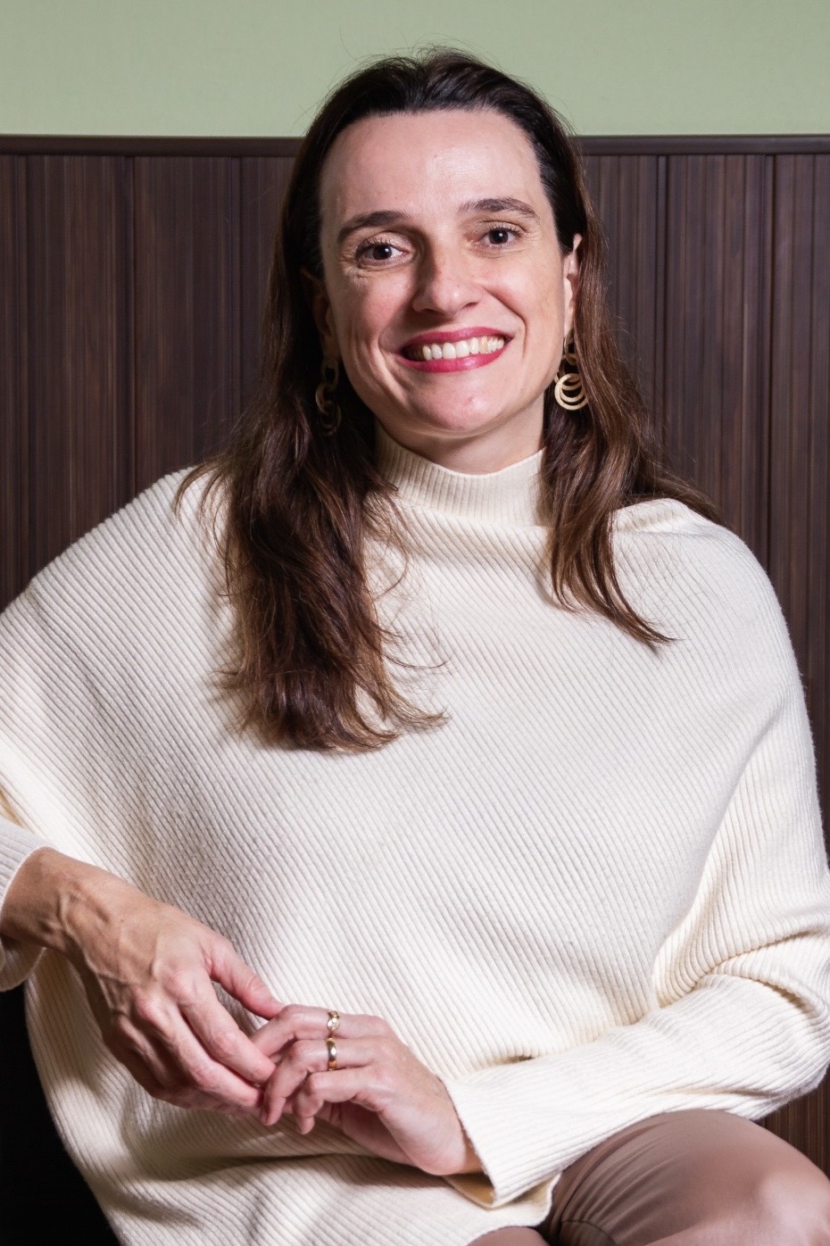 Liana Vertuan sentada, usando blusa de tricô claro